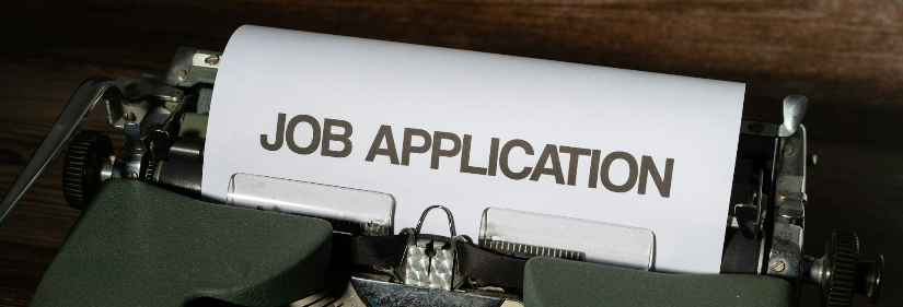 a typewriter with a job application printed on it